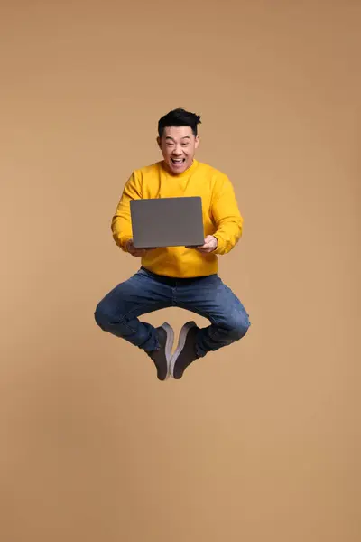 Homem Feliz Com Laptop Pulando Fundo Bege — Fotografia de Stock
