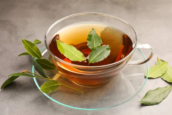 Tasse Frisch Gebrühter Tee Mit Lorbeerblättern Auf Grauem Tisch Nahaufnahme — Stockfoto