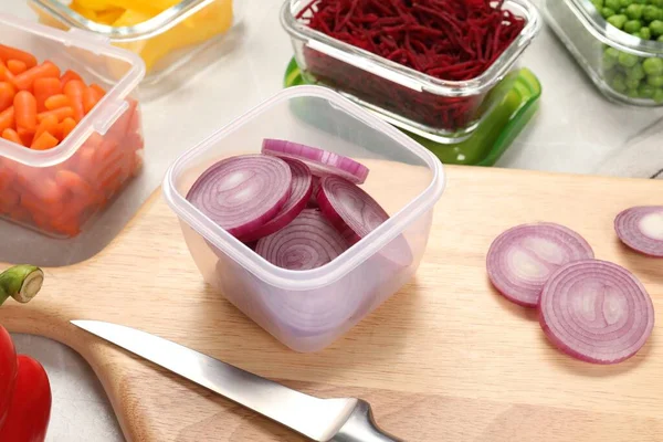 stock image Containers with cut onion and fresh products on table. Food storage