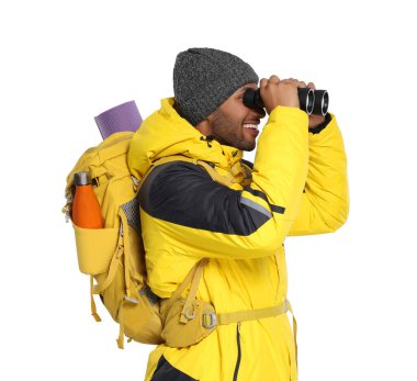 Beyaz arka planda dürbünle bakan sırt çantalı mutlu bir turist.