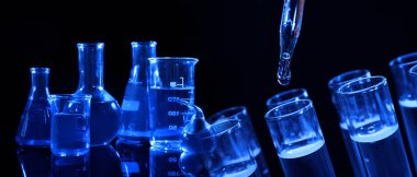 Kimya ve kimyasal araştırma. Siyah arka planda sıvılar bulunan farklı laboratuvar cam kolajı, mavi ton etkisi. Pankart tasarımı