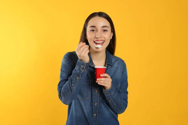 Portrait Happy Woman Eating Tasty Yogurt Orange Background — Stok Foto
