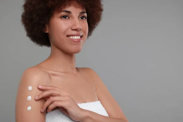 Mooie Jonge Vrouw Aanbrengen Lichaam Crème Arm Grijze Achtergrond Ruimte — Stockfoto