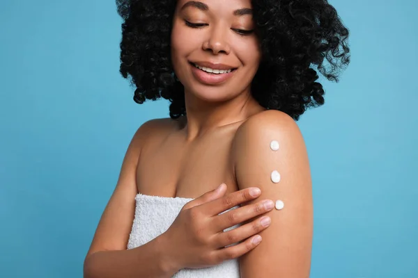 Young Woman Applying Body Cream Shoulder Light Blue Background Closeup — 스톡 사진