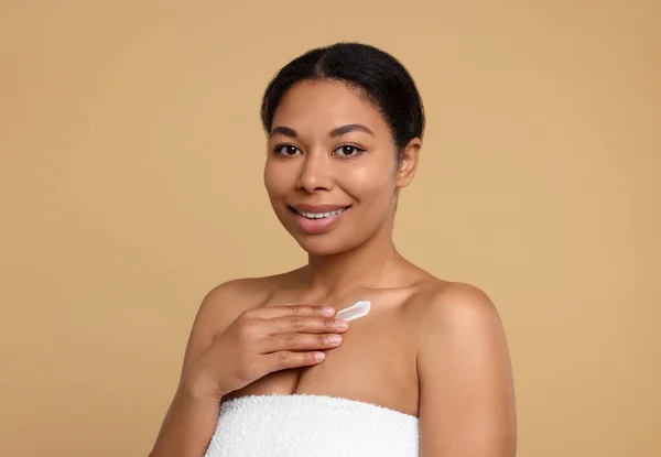Jonge Vrouw Aanbrengen Crème Lichaam Beige Achtergrond — Stockfoto