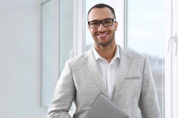 現代オフィスのラップトップで若いビジネスマンを笑顔 — ストック写真
