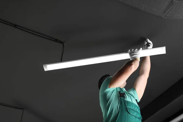 stock image Ceiling light. Electrician installing led linear lamp indoors. Space for text