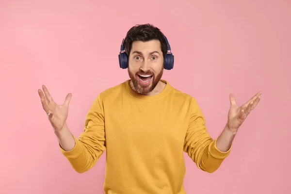 Emocjonalny Człowiek Słuchający Muzyki Słuchawkami Różowym Tle — Zdjęcie stockowe