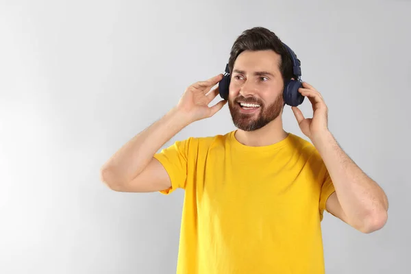 Szczęśliwy Człowiek Słuchający Muzyki Słuchawkami Jasnoszarym Tle Miejsce Tekst — Zdjęcie stockowe