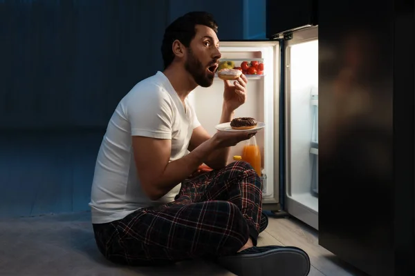 Мужчина Ест Пончики Возле Холодильника Кухне Ночью Плохая Привычка — стоковое фото