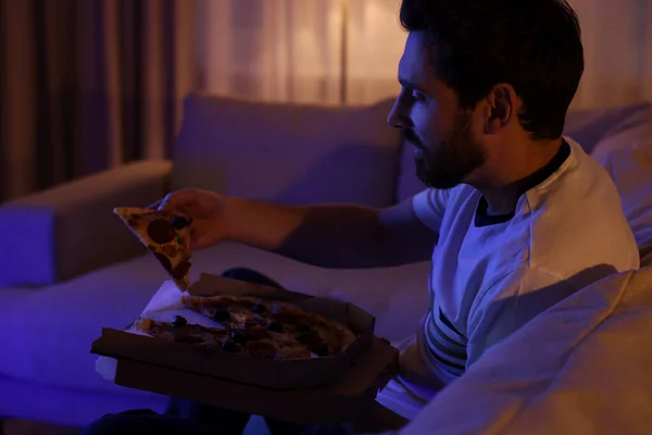 男人晚上在沙发上看电视时吃披萨 坏习惯 — 图库照片