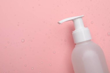 Pembe arka planda ıslak yüz temizleme ürünü, üst manzara. Metin için boşluk