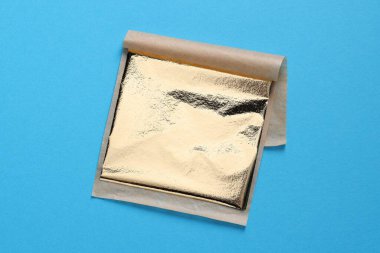 Açık mavi arkaplanda yenilebilir altın yaprak sayfası, üst görünüm
