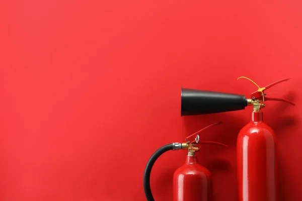 stock image Fire extinguishers on red background, flat lay. Space for text