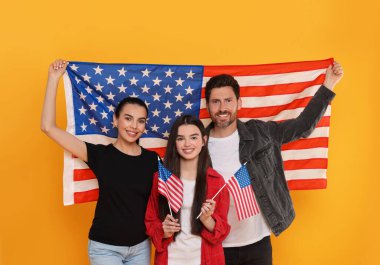 4 Temmuz - ABD 'nin Bağımsızlık Günü. Sarı arka planda Amerikan bayrakları olan mutlu bir aile