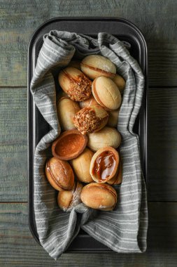 Yeni pişirilmiş ev yapımı ceviz şekilli kurabiyeler ahşap masada, üst tarafta.