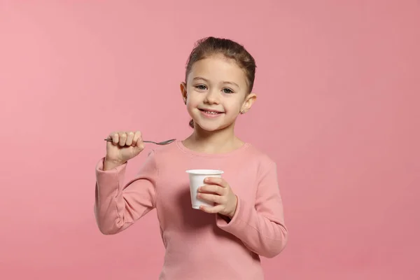 Flicka Med Välsmakande Yoghurt Rosa Bakgrund — Stockfoto