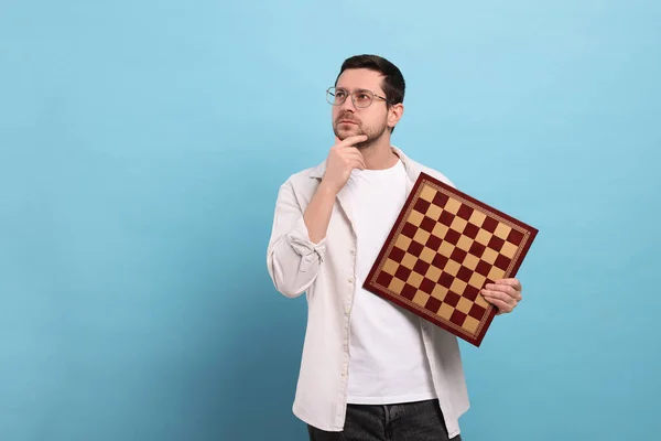 Προσεκτικός Άνθρωπος Κρατώντας Σκακιέρα Γαλάζιο Φόντο Χώρος Για Κείμενο — Φωτογραφία Αρχείου