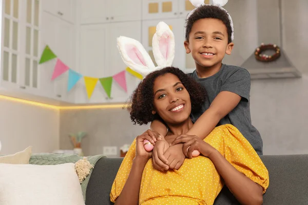 stock image Happy African American mother with Easter eggs and her cute son in kitchen