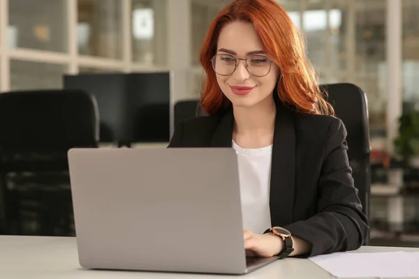 オフィスのホワイトデスクでノートパソコンを扱う女性 — ストック写真