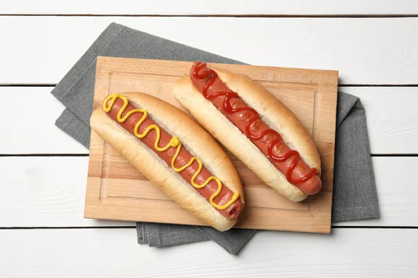 Deliciosos Cachorros Quentes Com Mostarda Ketchup Mesa Madeira Branca Vista — Fotografia de Stock