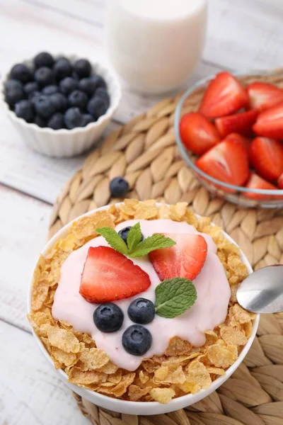 美味的脆玉米片 酸奶和新鲜的浆果放在白色木制桌子上的碗里 健康早餐 — 图库照片