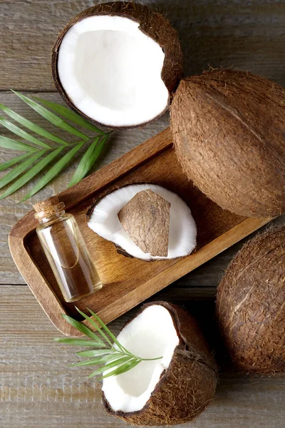 Fles Biologische Kokosolie Vers Fruit Bladeren Houten Tafel Plat Gelegd — Stockfoto