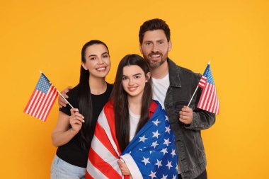 4 Temmuz - ABD 'nin Bağımsızlık Günü. Sarı arka planda Amerikan bayrakları olan mutlu bir aile