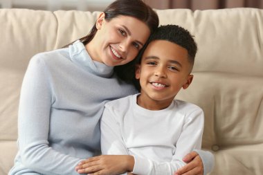 Anne ve Afrikalı Amerikalı oğlu kanepede. Uluslararası aile