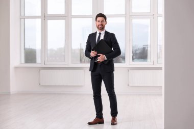 Yeni dairede deri portföyü olan mutlu emlakçı.