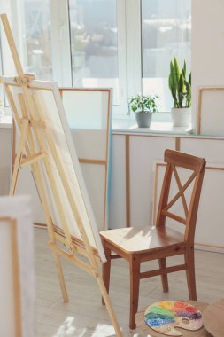 Sanatçının stüdyosunun penceresinin yanında tuvali ve sandalyesi olan Easel. Yaratıcı hobi