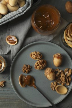Taze pişirilmiş ev yapımı ceviz şekilli kurabiyeler ve ahşap masada haşlanmış süt, düz yatıyordu.