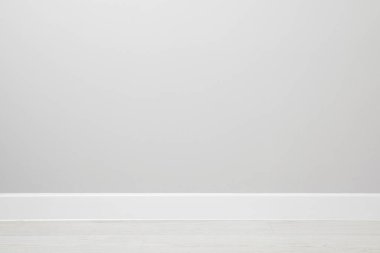 Kapalı duvarın yakınındaki kaplamalı zeminde beyaz bir kaide.