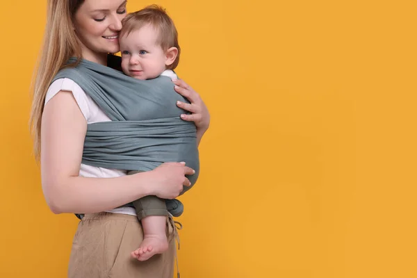 Moeder Houdt Haar Kind Baby Wrap Oranje Achtergrond Close Ruimte — Stockfoto