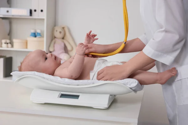 儿科医生用听诊器对可爱的小宝宝进行检查 并在临床 特写镜头中称重 — 图库照片