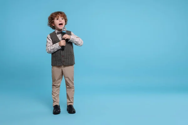 Симпатичный Мальчик Микрофоном Поющий Голубом Фоне Место Текста — стоковое фото