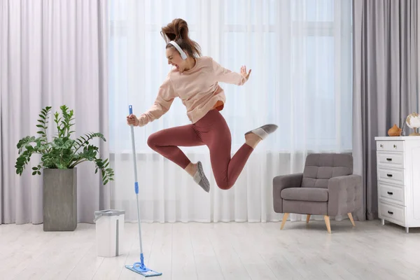 Desfrutar Limpeza Mulher Fones Ouvido Pulando Com Esfregona Dentro Casa — Fotografia de Stock