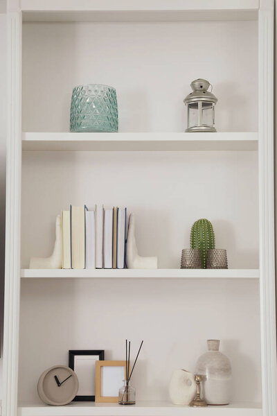 Stylish shelves with different decor elements. Interior design