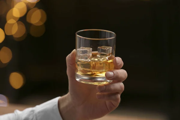Uomo Che Tiene Bicchiere Whisky Con Cubetti Ghiaccio Contro Luci — Foto Stock