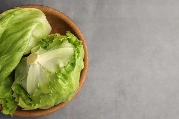 用新鲜的绿色冰镇生菜头和叶子在灰色桌子上的碗 顶部视图 案文的篇幅 — 图库照片