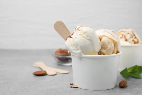 Мороженое Карамельным Соусом Бумажной Чашке Светло Сером Столе Крупным Планом — стоковое фото