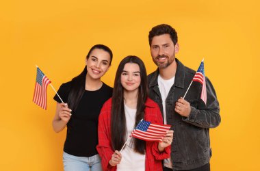 4 Temmuz - ABD 'nin Bağımsızlık Günü. Sarı arka planda Amerikan bayrakları olan mutlu bir aile