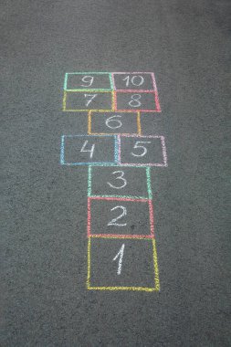 Açık havada asfalt üzerine renkli tebeşirle çizilmiş seksek.