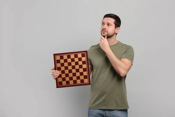 Προσεκτικός Άντρας Που Κρατάει Την Σκακιέρα Ανοιχτό Γκρι Φόντο Χώρος — Φωτογραφία Αρχείου