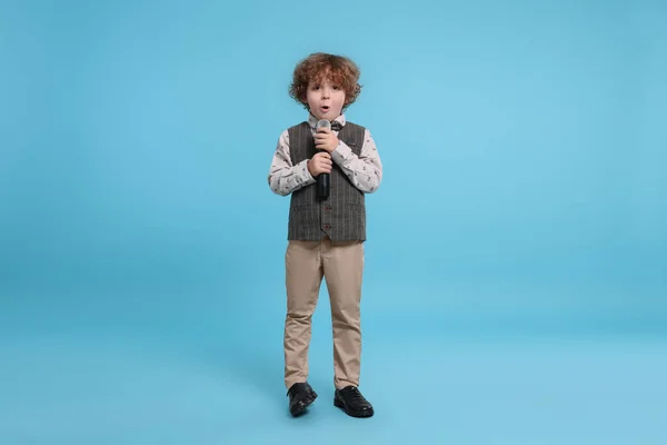 Милый Мальчик Микрофоном Поющий Голубом Фоне — стоковое фото