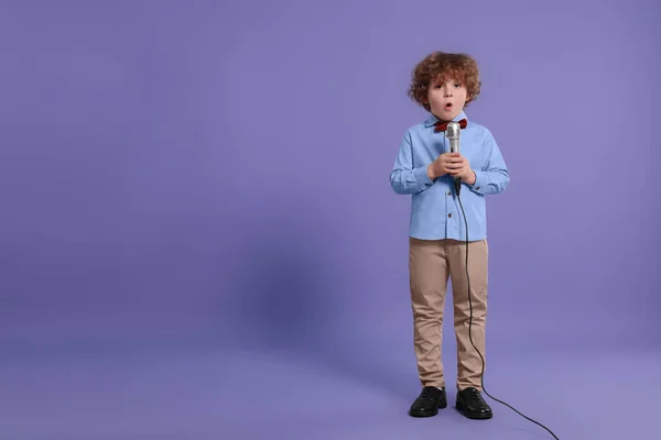 Симпатичный Мальчик Микрофоном Поющий Фиолетовом Фоне Место Текста — стоковое фото