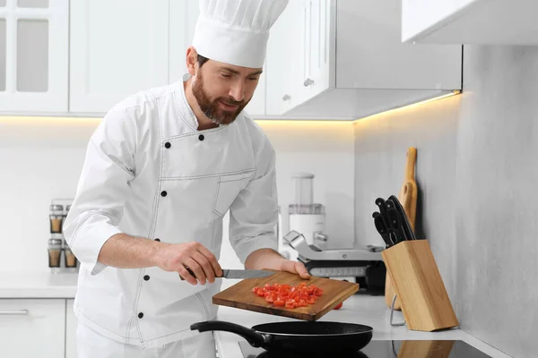 stock image Professional chef putting cut tomatoes into frying pan in kitchen