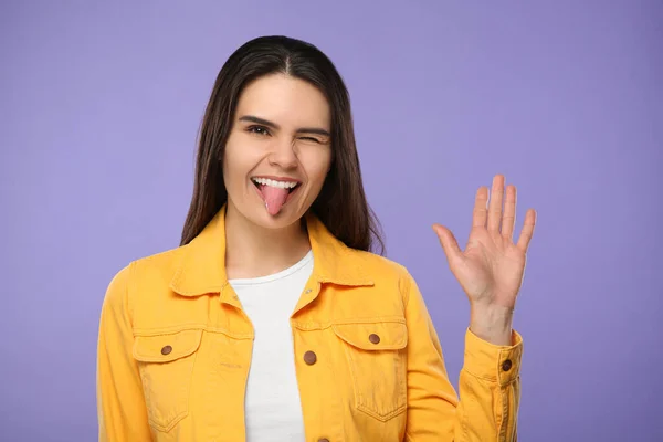 Szczęśliwa Młoda Kobieta Pokazuje Swój Język Fioletowym Tle — Zdjęcie stockowe