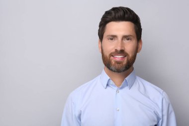 Açık gri arkaplanda yakışıklı bir adamın portresi, metin için boşluk