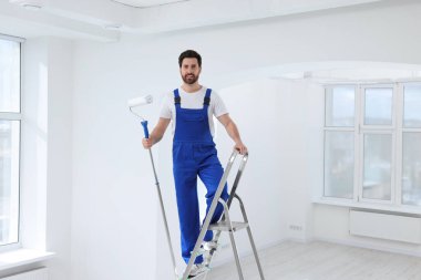 Merdivende merdiveni olan tamirci. Tavan resmi.